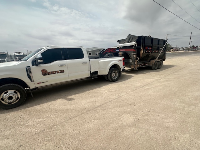 SD Services trailer illuminated at dusk on a rugged worksite.