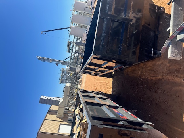 Open-top SD Services trailer on a dirt jobsite.